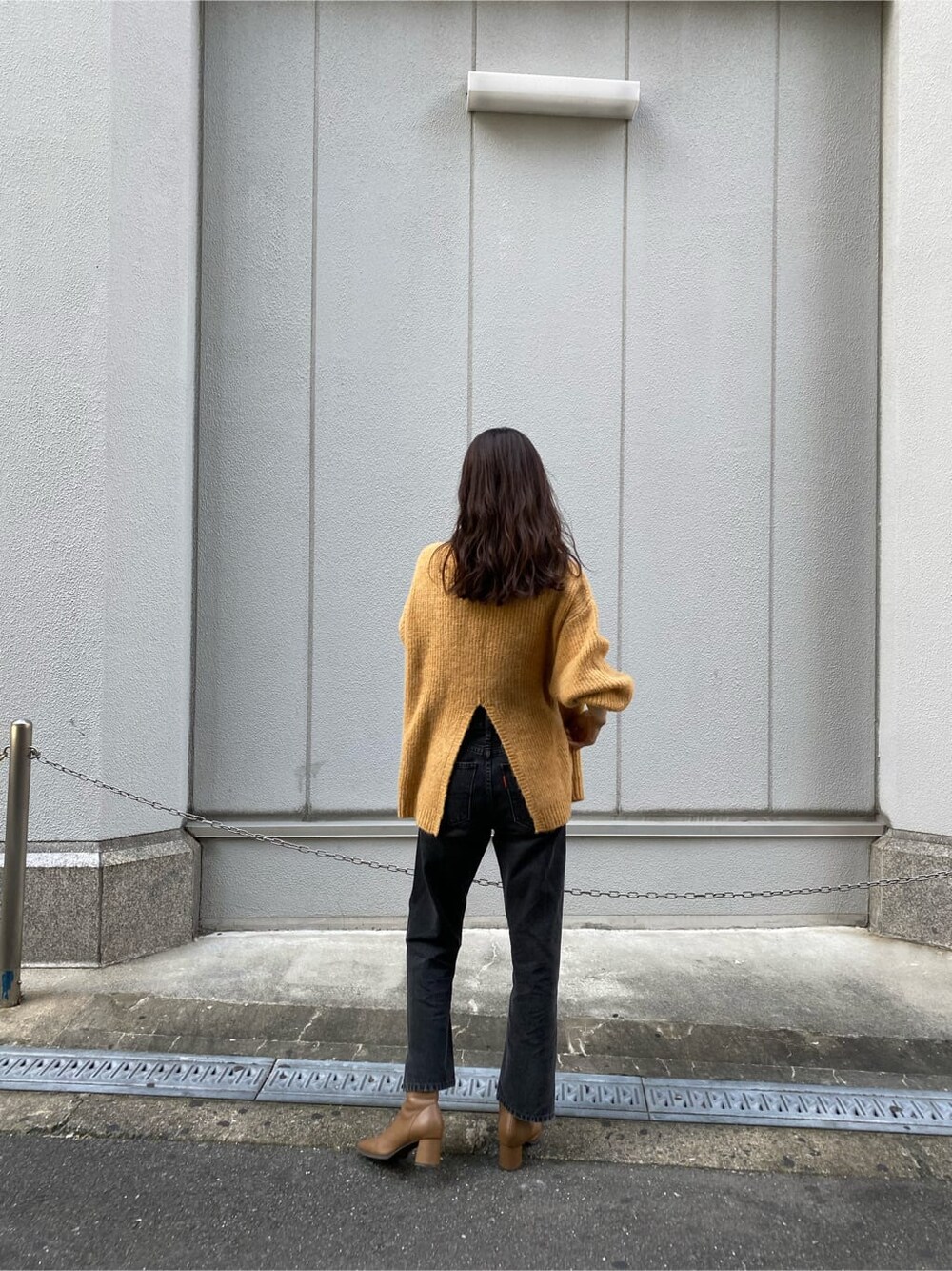 ブラック系のデニムパンツ、イエロー系のニット/セーターを着用したレディースの秋コーディネートの4枚目の写真