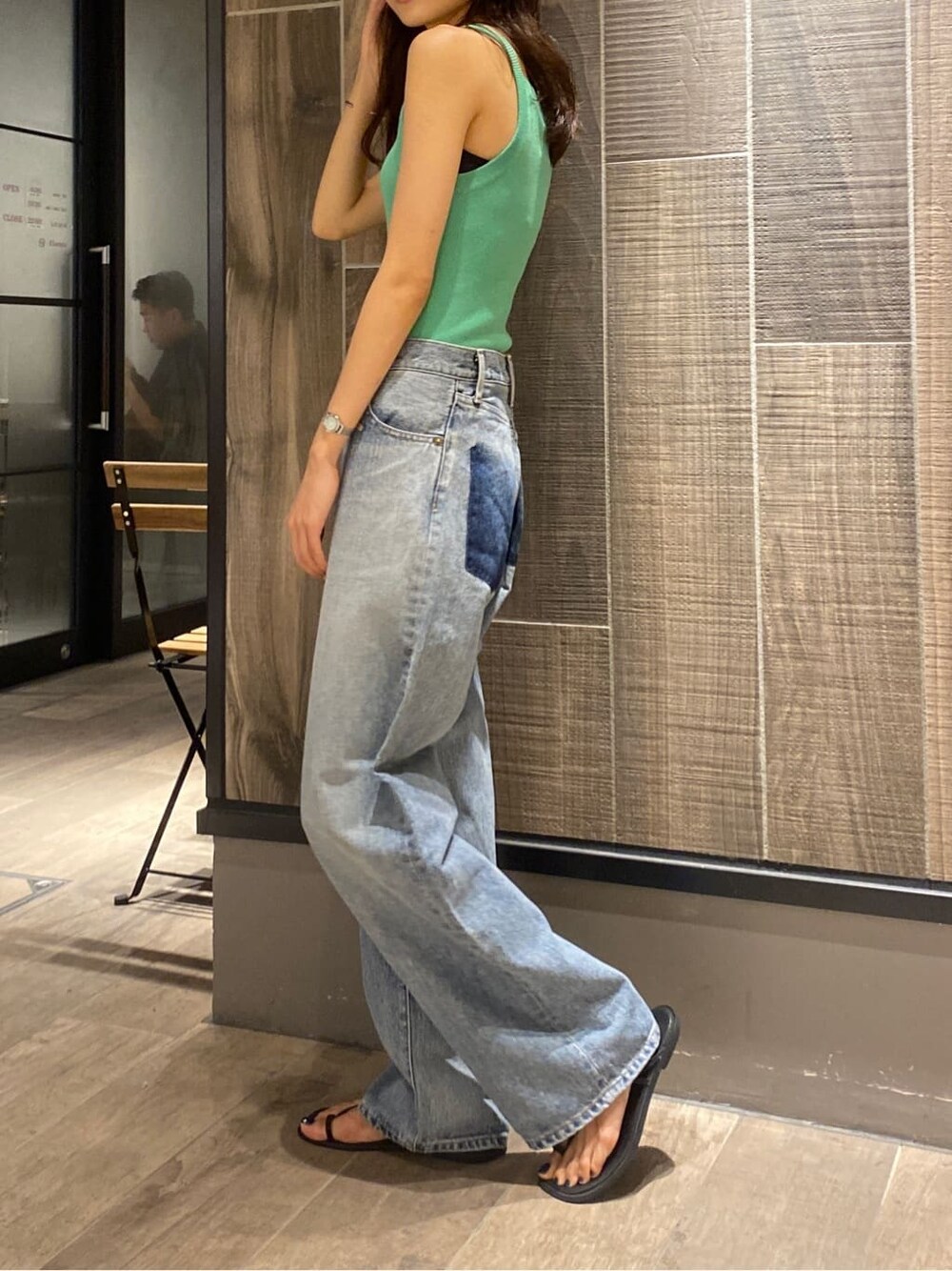 グリーン系のタンクトップ、ブルー系のデニムパンツを着用したレディースの夏コーディネートの3枚目の写真