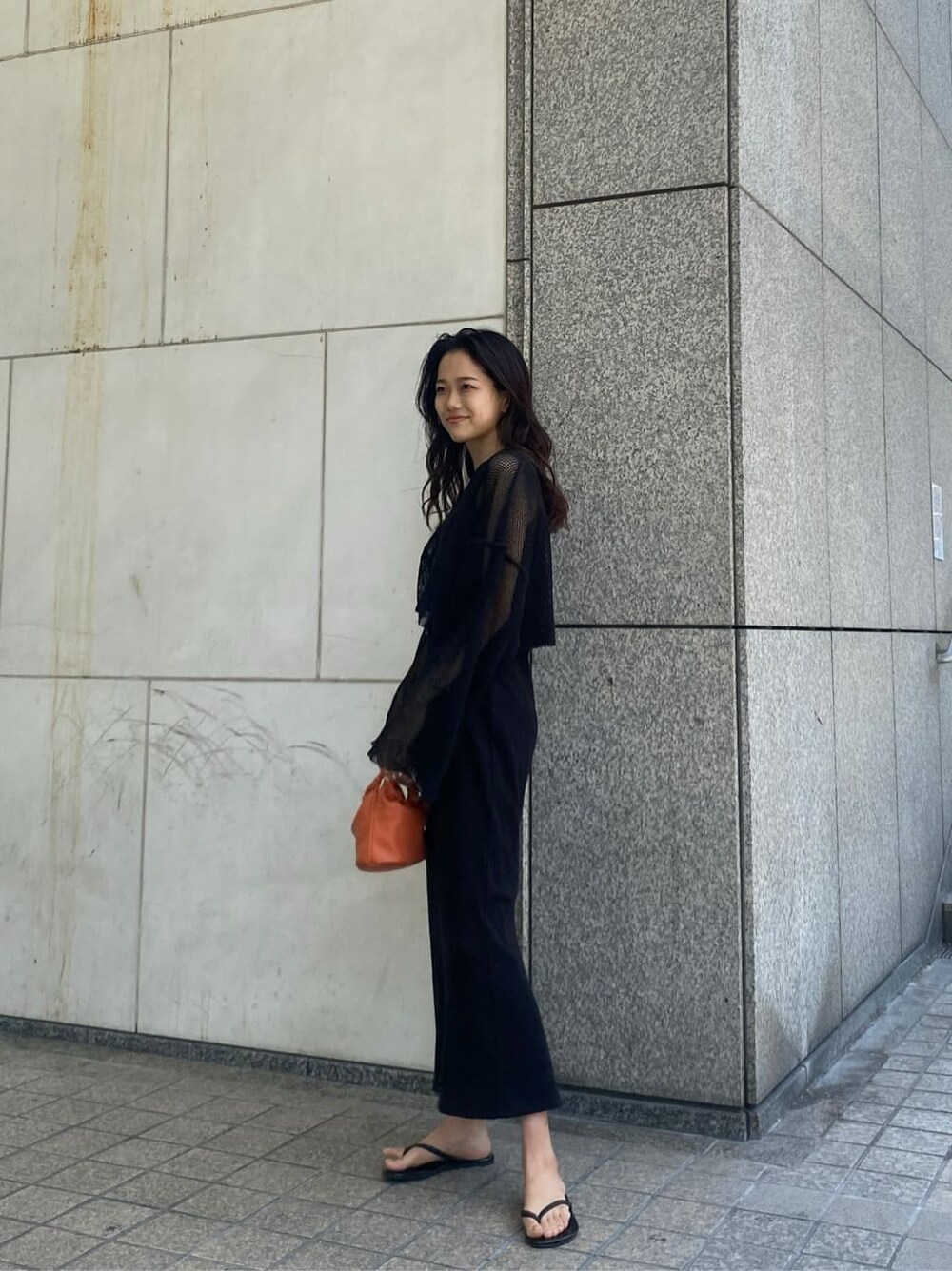 ブラック系のTシャツ/カットソー、ブラック系のワンピース、オレンジ系のハンドバッグを着用したレディースの春コーディネートの2枚目の写真