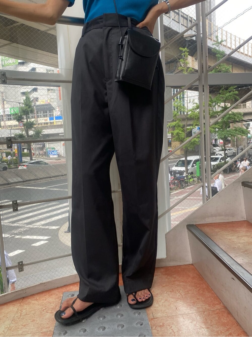 ブルー系のTシャツ/カットソー、グレー系のスラックスを着用したレディースの夏コーディネートの6枚目の写真