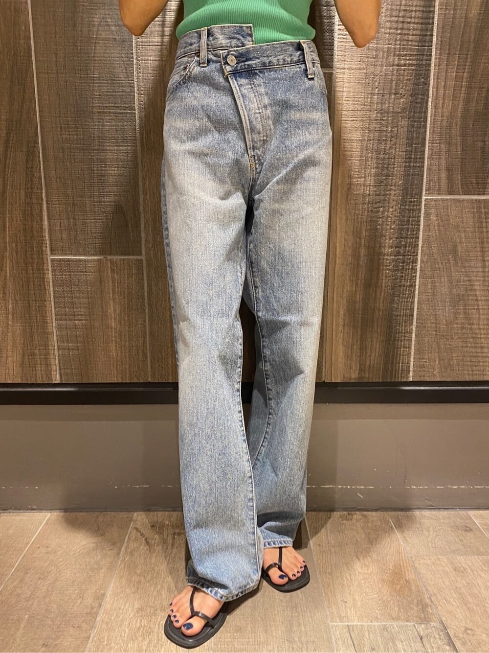 グリーン系のタンクトップ、ブルー系のデニムパンツを着用したレディースの夏コーディネートの7枚目の写真