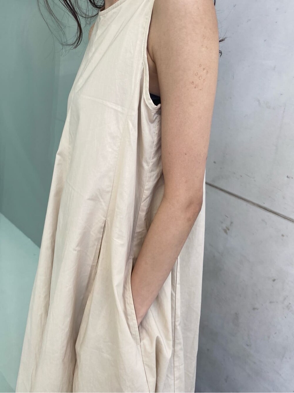 ブルー系のデニムパンツ、ベージュ系のワンピースを着用したレディースの春コーディネートの7枚目の写真