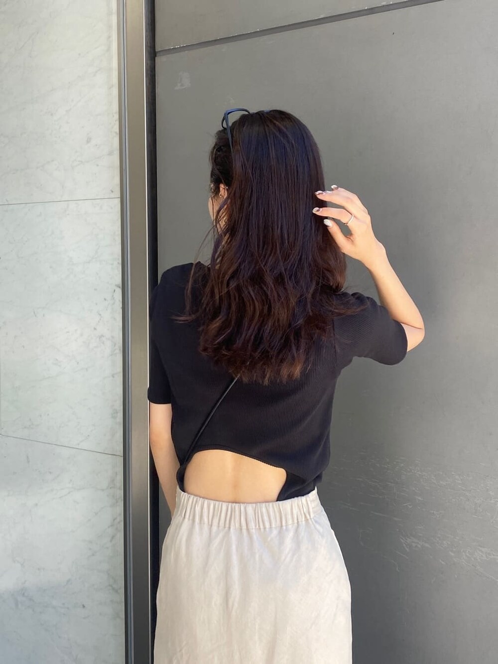 ベージュ系のスカート、ブラック系のTシャツ/カットソーを着用したレディースの夏コーディネートの4枚目の写真