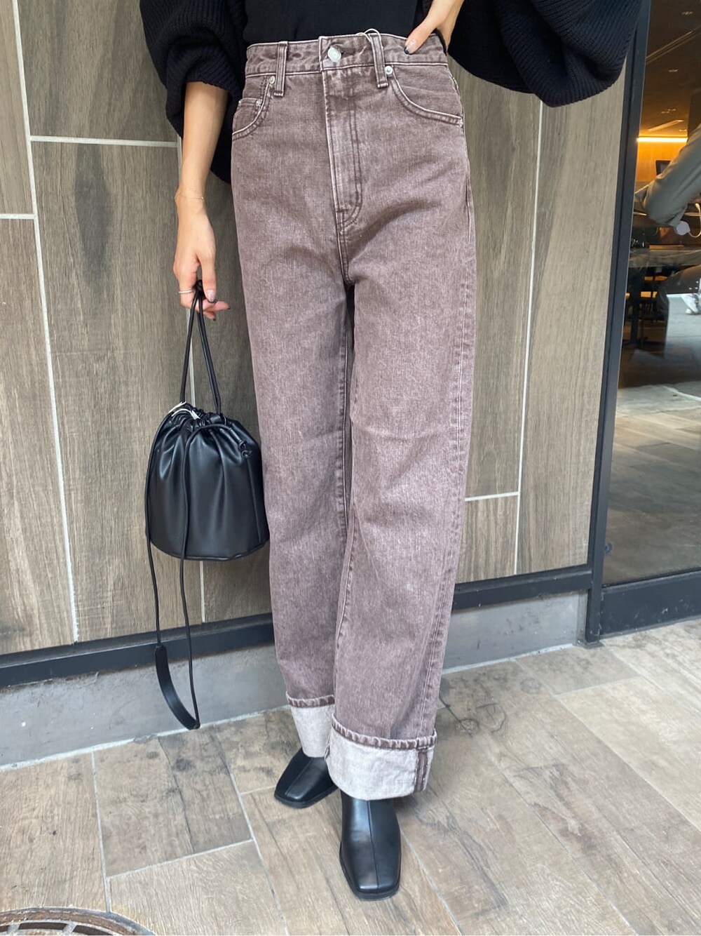 ブラック系のブーツ、ブラウン系のデニムパンツ、ブラック系のカーディガン/ボレロを着用したレディースの秋コーディネートの7枚目の写真