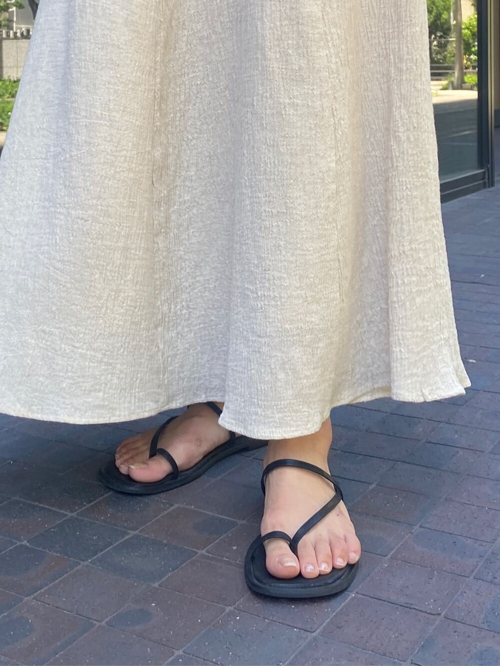 ブラック系のサンダル、ホワイト系のワンピース、ベージュ系のハットを着用したレディースの夏コーディネートの8枚目の写真