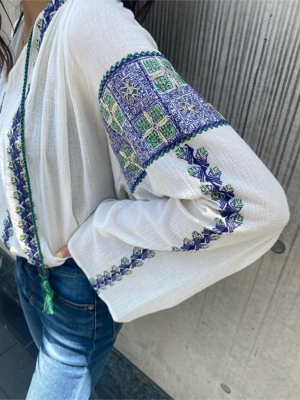 ブルー系のデニムパンツ、ホワイト系のシャツ/ブラウス、ブラック系のサンダルを着用したレディースの春コーディネートの4枚目の写真