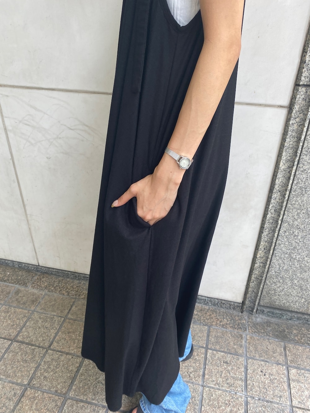 ブラック系のワンピース、ホワイト系のタンクトップ、ブルー系のデニムパンツを着用したレディースの夏コーディネートの6枚目の写真