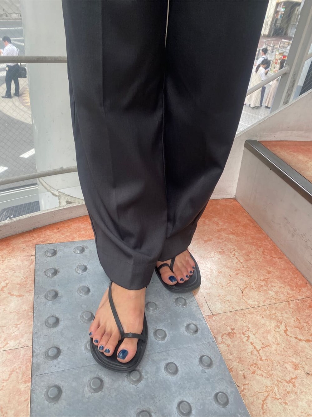 ブルー系のTシャツ/カットソー、グレー系のスラックスを着用したレディースの夏コーディネートの8枚目の写真