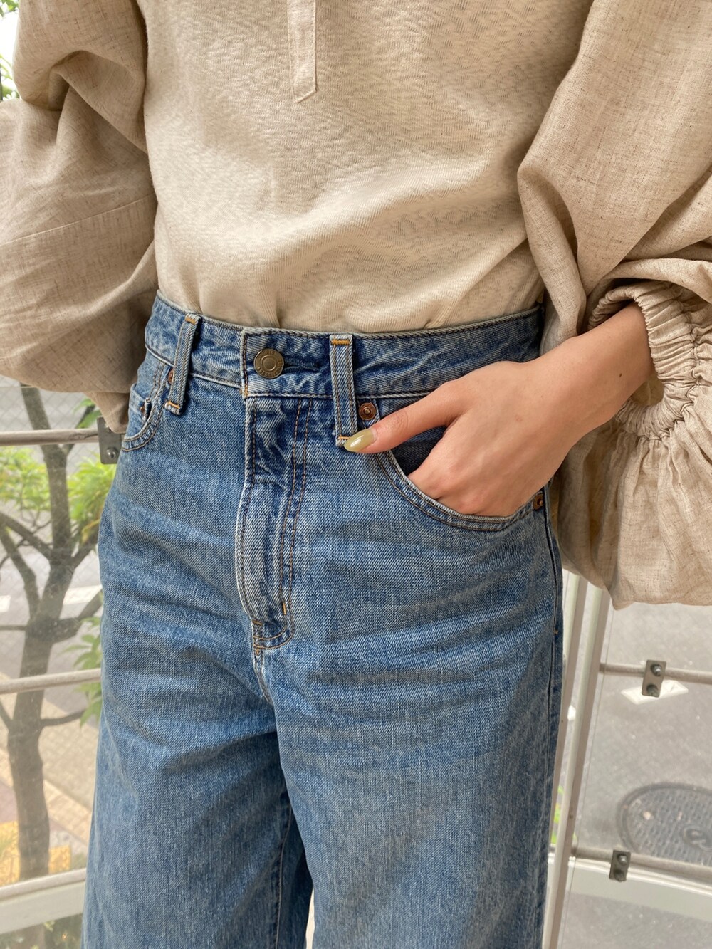 ベージュ系のシャツ/ブラウス、ブルー系のデニムパンツ、ゴールド系のサンダルを着用したレディースの春コーディネートの6枚目の写真