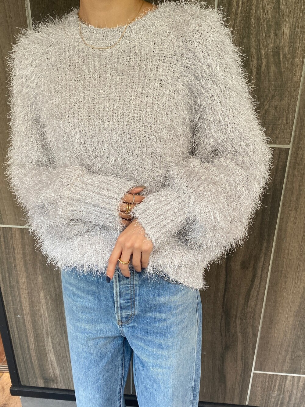 シルバー系のニット/セーター、ブルー系のデニムパンツを着用したレディースの秋コーディネートの3枚目の写真