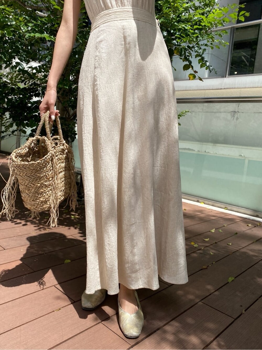 ベージュ系のかごバッグ、ホワイト系のワンピースを着用したレディースの春コーディネートの6枚目の写真