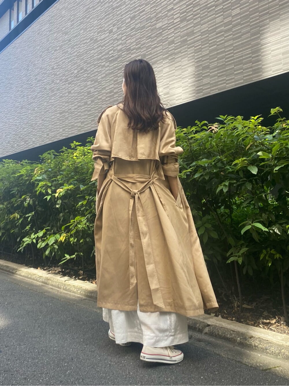 ベージュ系のトレンチコート、ホワイト系のスカート、グレー系のTシャツ/カットソーを着用したレディースの夏コーディネートの3枚目の写真
