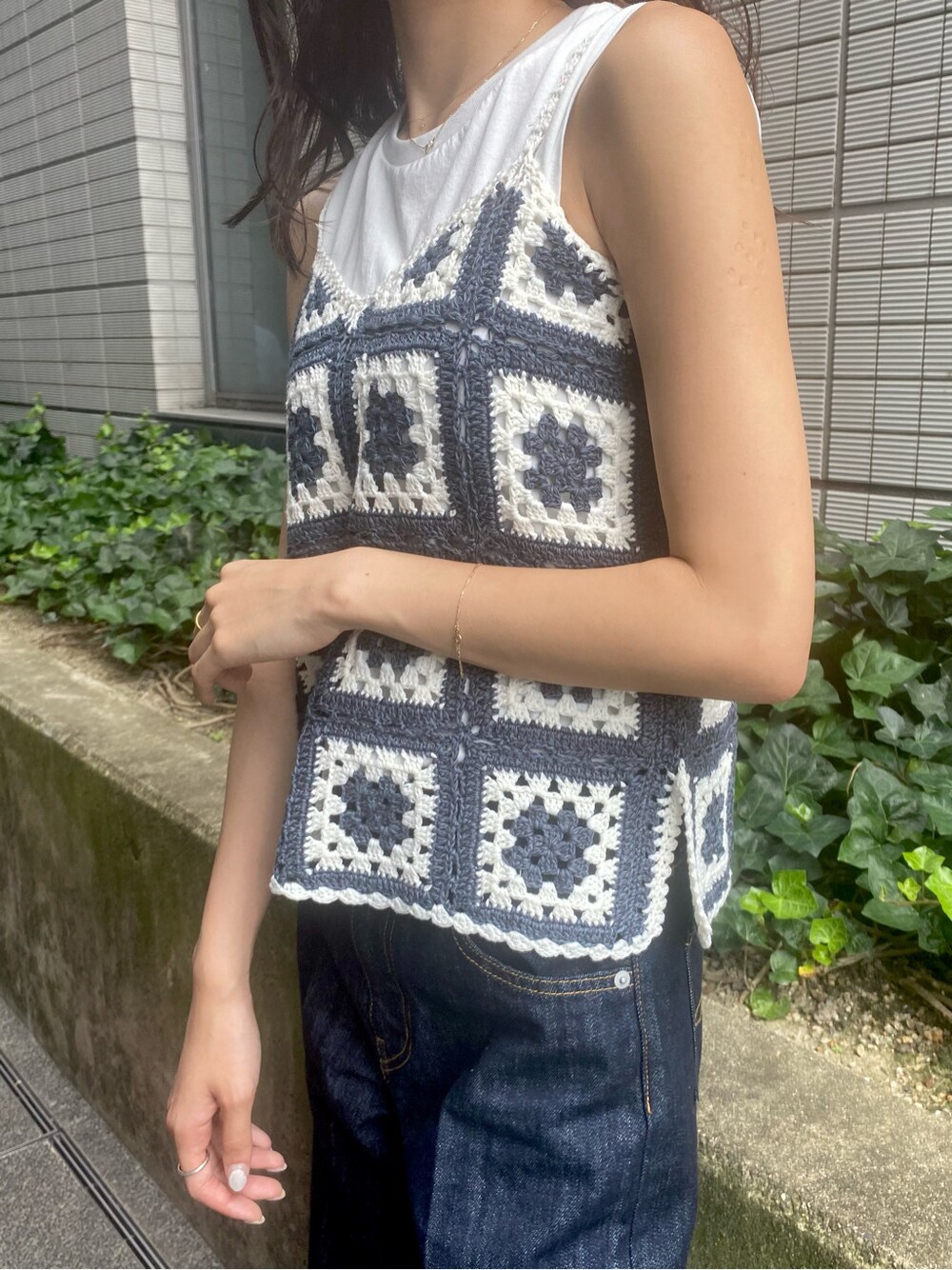 ホワイト系のタンクトップ、ブルー系のデニムパンツを着用したレディースの夏コーディネートの3枚目の写真