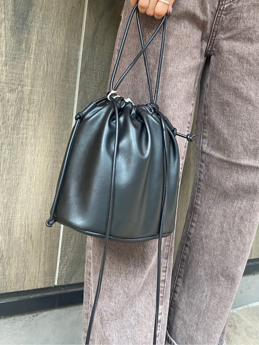 ブラック系のブーツ、ブラウン系のデニムパンツ、ブラック系のカーディガン/ボレロを着用したレディースの秋コーディネートの6枚目の写真