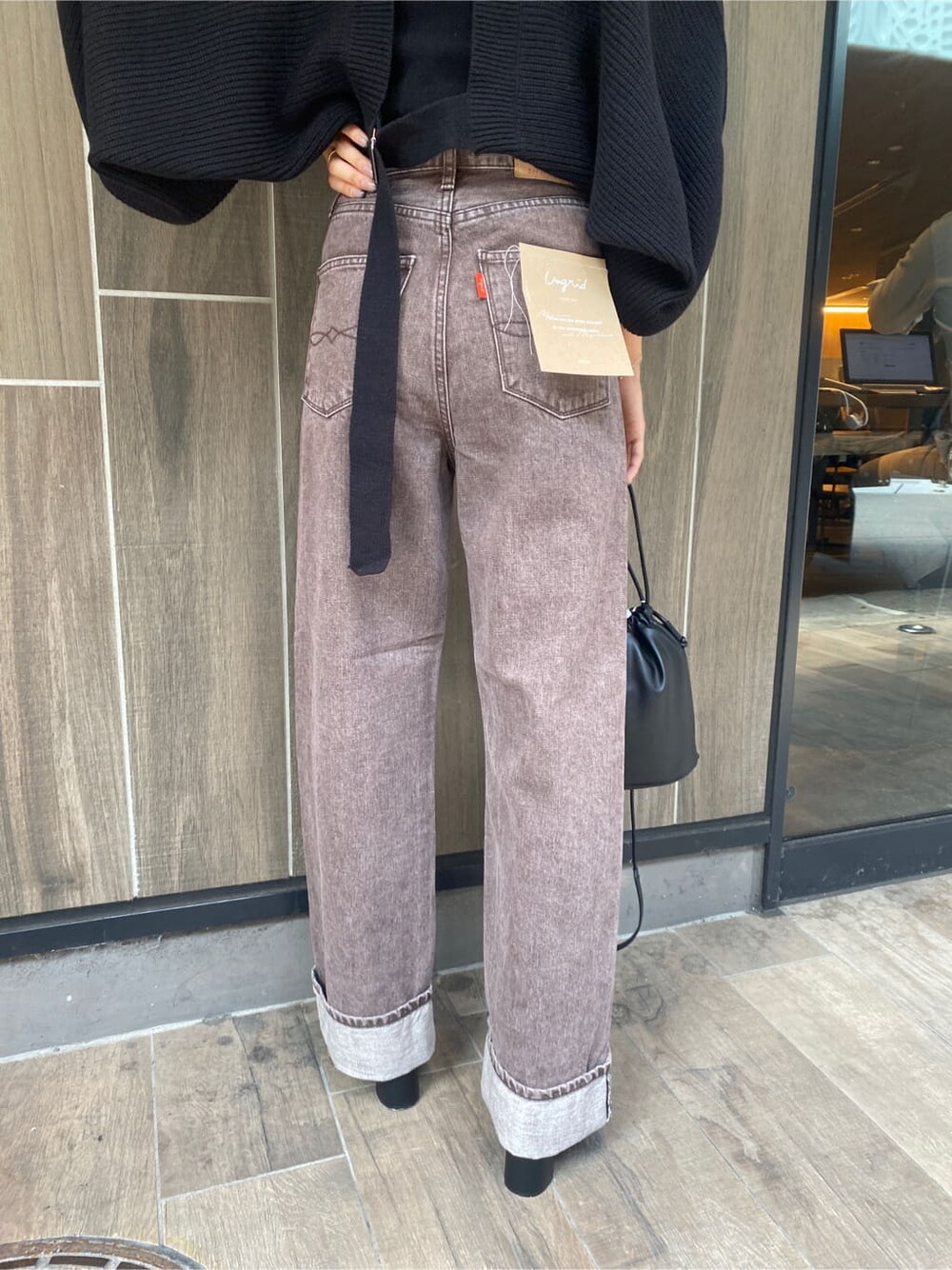 ブラック系のブーツ、ブラウン系のデニムパンツ、ブラック系のカーディガン/ボレロを着用したレディースの秋コーディネートの8枚目の写真