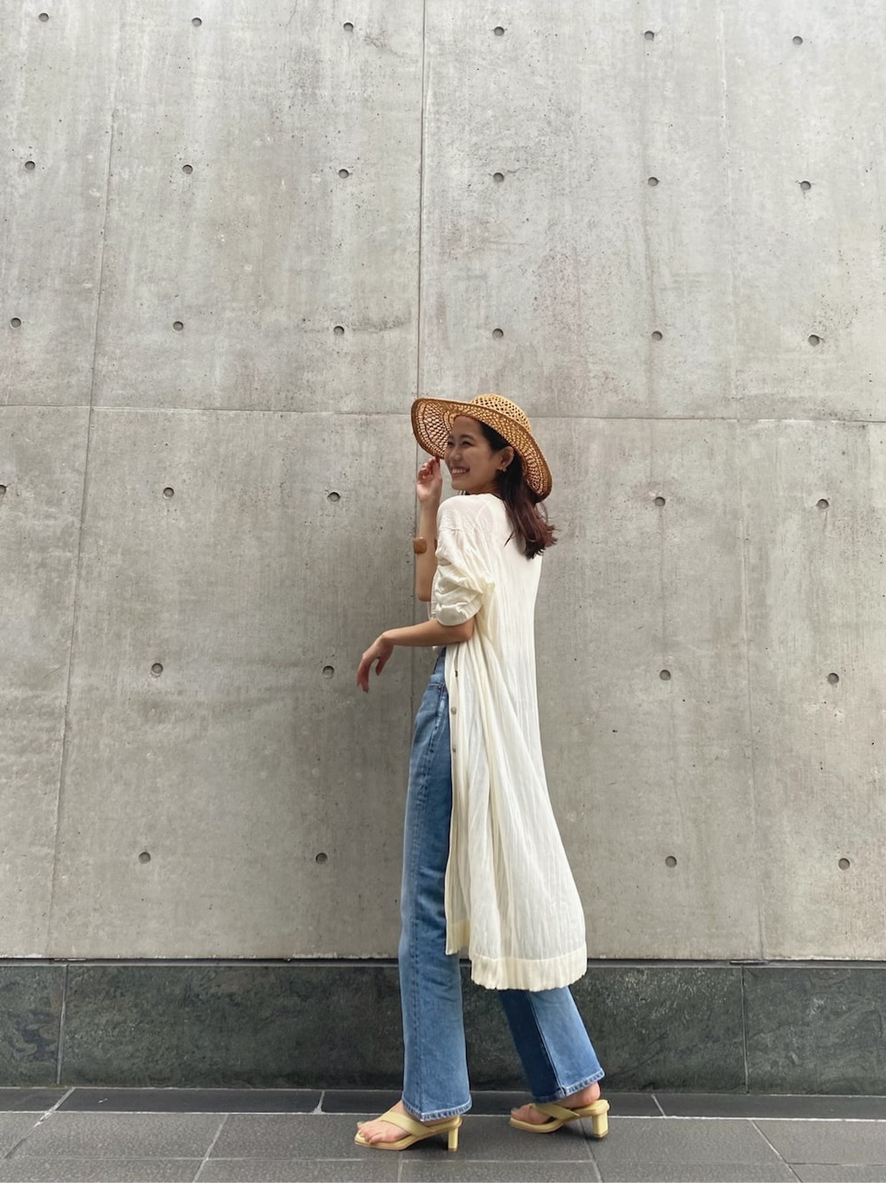 ホワイト系のタンクトップ、ブルー系のデニムパンツ、ホワイト系のカーディガン/ボレロを着用したレディースの春コーディネートの2枚目の写真