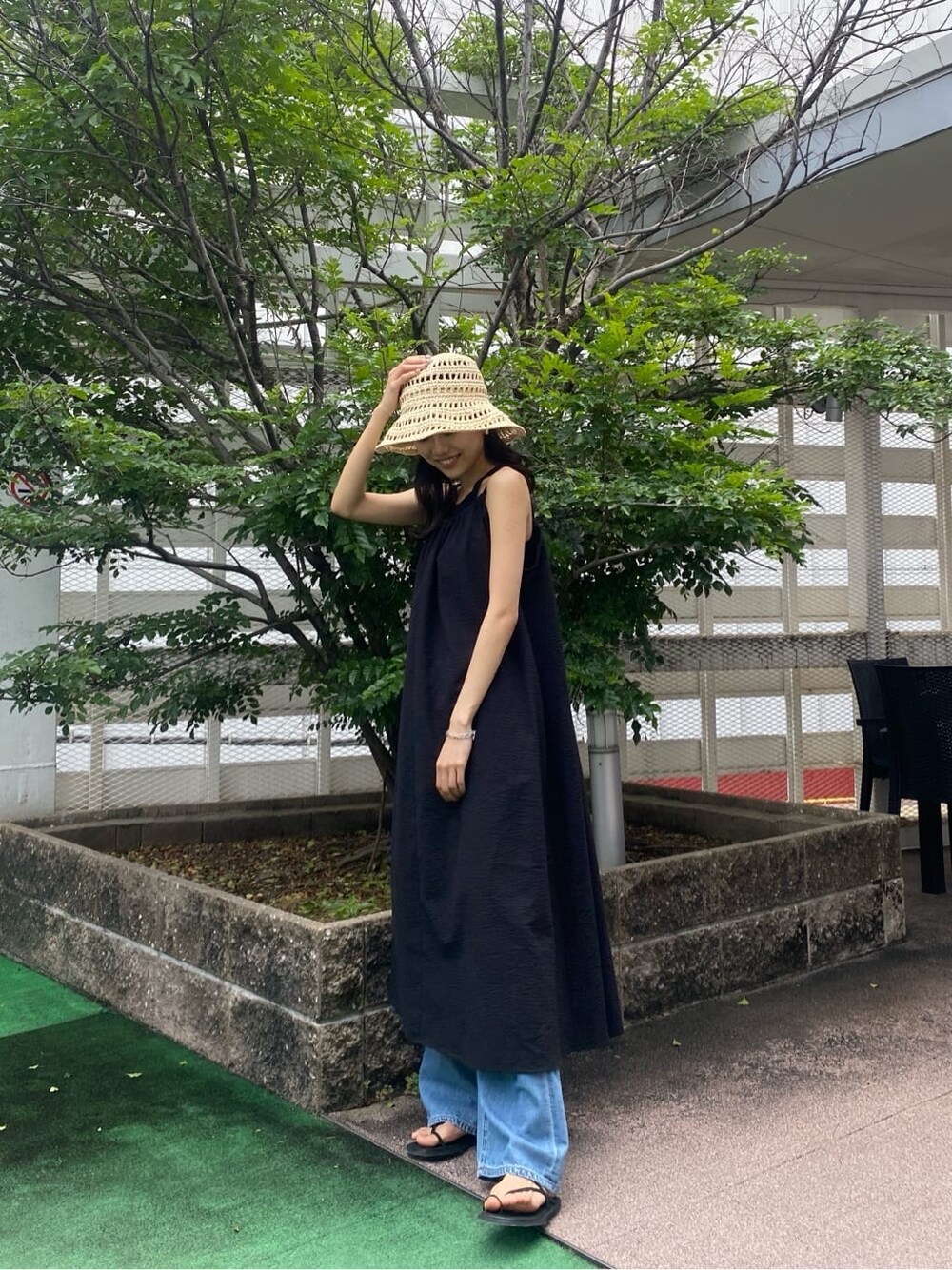 ブラック系のサンダル、ブラック系のワンピース、ブラック系のタンクトップを着用したレディースの夏コーディネートの3枚目の写真