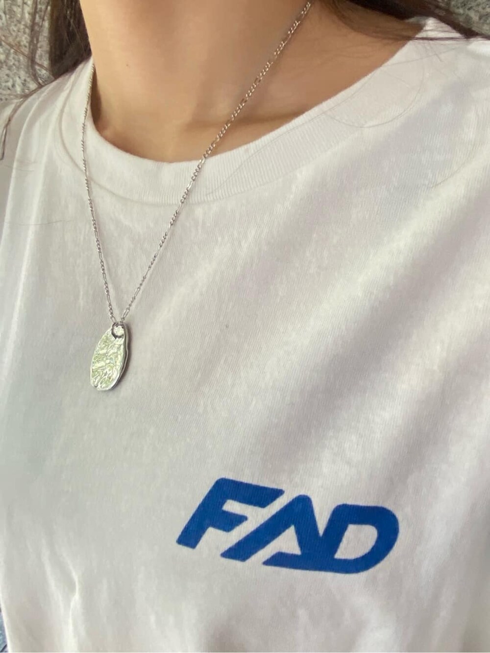 グレー系のスカート、ホワイト系のタンクトップ、シルバー系のネックレスを着用したレディースの春コーディネートの6枚目の写真