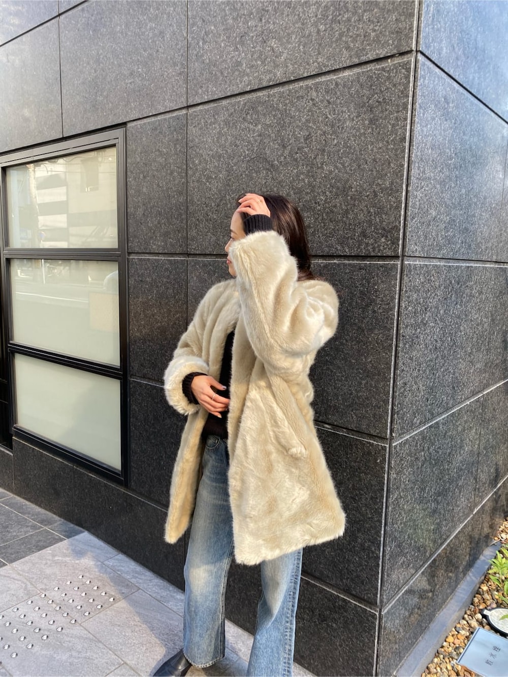 グレー系のその他アウター、ブルー系のデニムパンツ、ブラック系のニット/セーターを着用したレディースの冬コーディネートの3枚目の写真