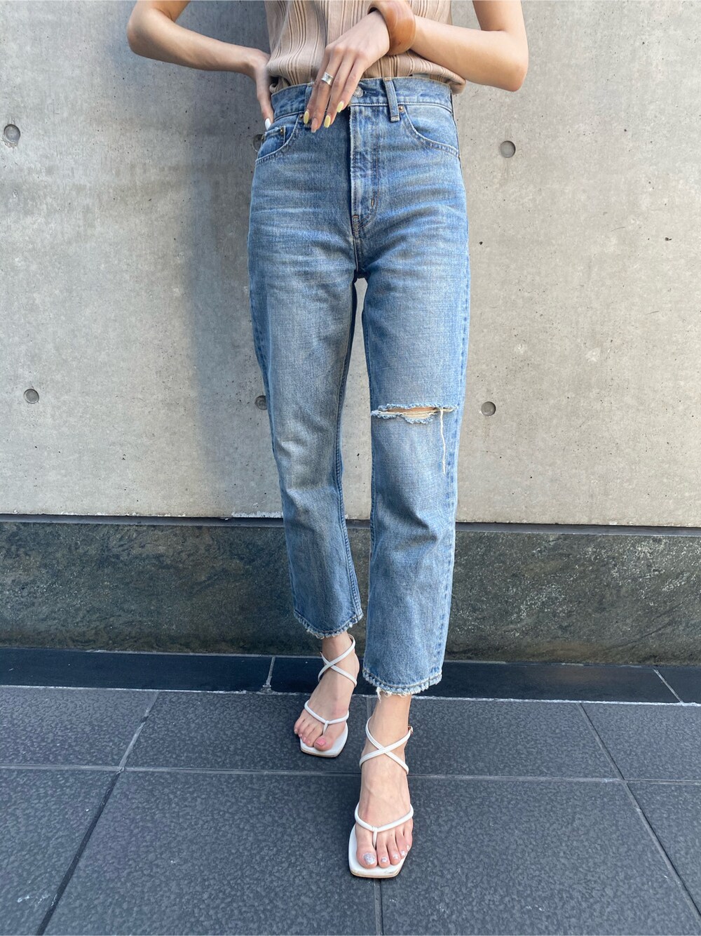 ブルー系のデニムパンツ、ベージュ系のTシャツ/カットソー、ベージュ系のハットを着用したレディースの春コーディネートの5枚目の写真