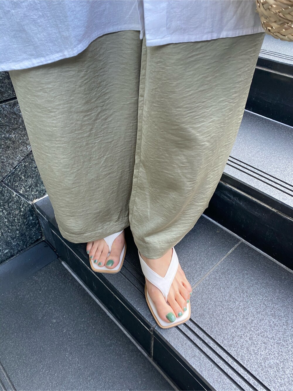 ホワイト系のサンダル、ベージュ系のかごバッグ、ホワイト系のワンピースを着用したレディースの春コーディネートの3枚目の写真