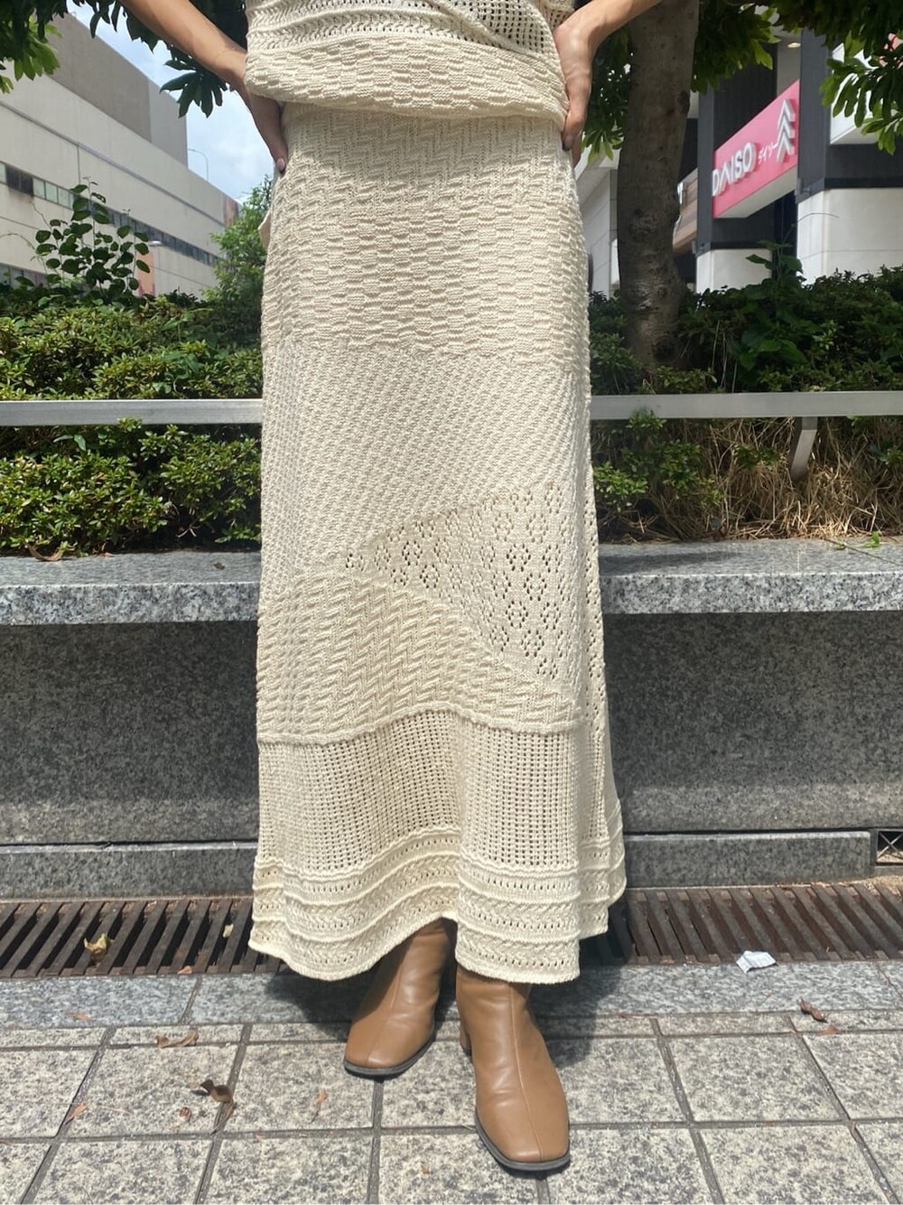 ホワイト系のスカート、ホワイト系のニット/セーター、ゴールド系のネックレスを着用したレディースの夏コーディネートの7枚目の写真