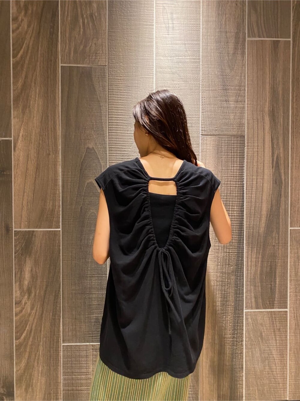 ブラック系のサンダル、ブラック系のTシャツ/カットソー、グリーン系のスカートを着用したレディースの夏コーディネートの6枚目の写真