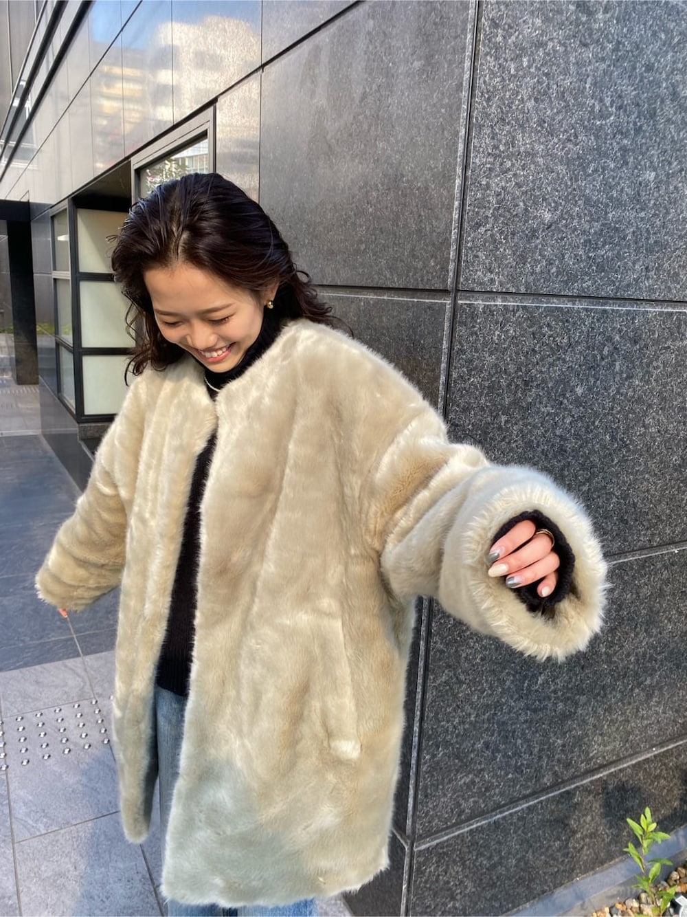 グレー系のその他アウター、ブルー系のデニムパンツ、ブラック系のニット/セーターを着用したレディースの冬コーディネートの2枚目の写真