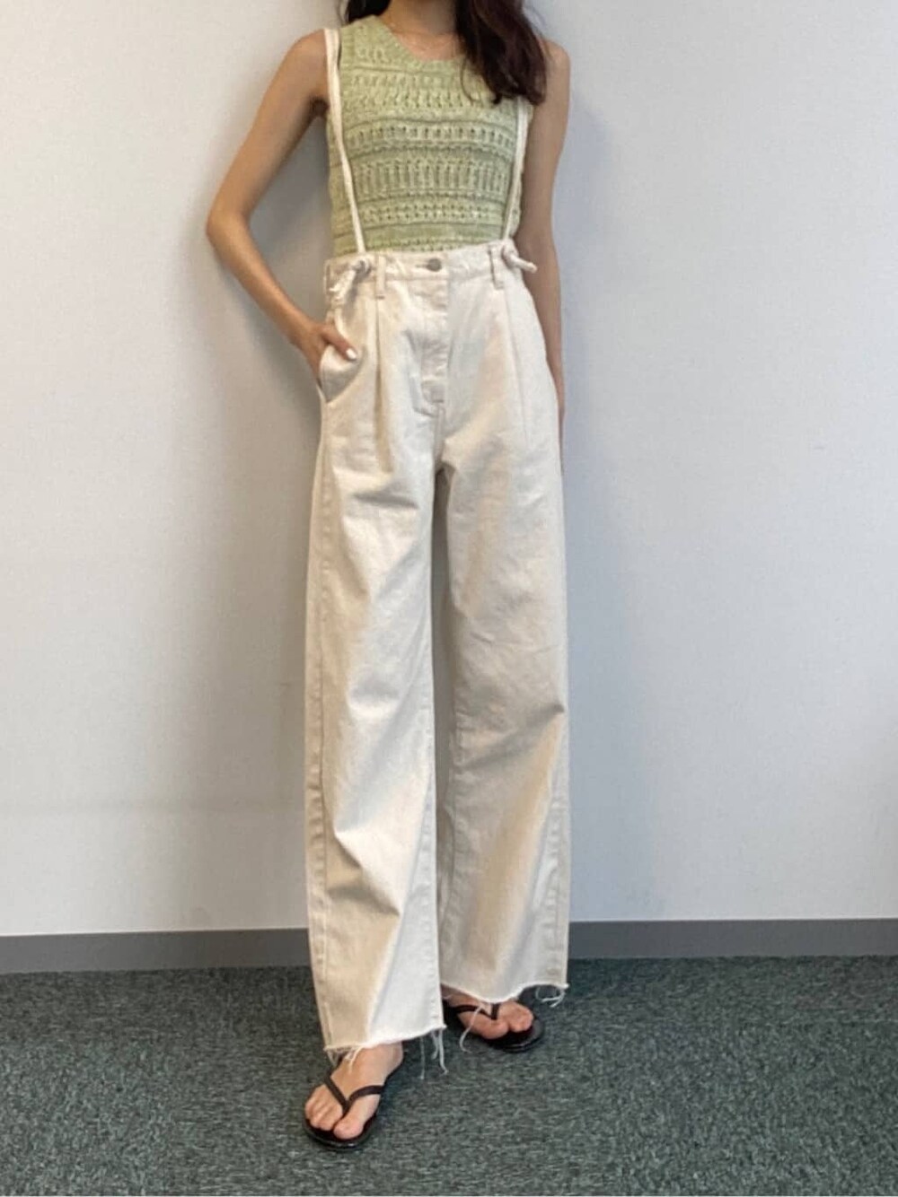 ホワイト系のデニムパンツ、グリーン系のニット/セーターを着用したレディースの春コーディネートの3枚目の写真