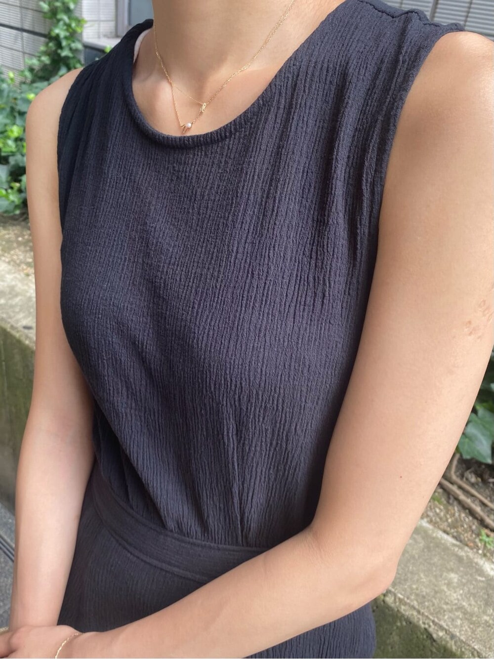 ブラック系のワンピース、ブラック系のサンダル、ホワイト系のタンクトップを着用したレディースの夏コーディネートの5枚目の写真