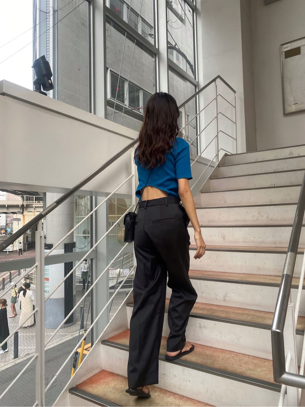 ブルー系のTシャツ/カットソー、グレー系のスラックスを着用したレディースの夏コーディネートの2枚目の写真