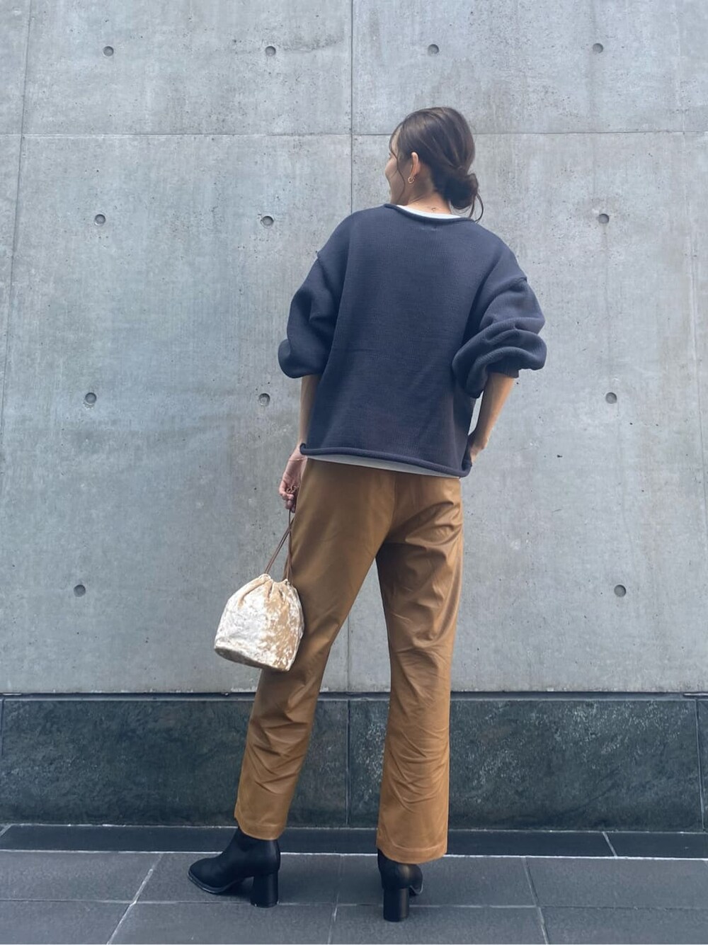 ブラウン系のその他パンツ、ブラック系のブーツ、ホワイト系のハンドバッグを着用したレディースの秋コーディネートの4枚目の写真