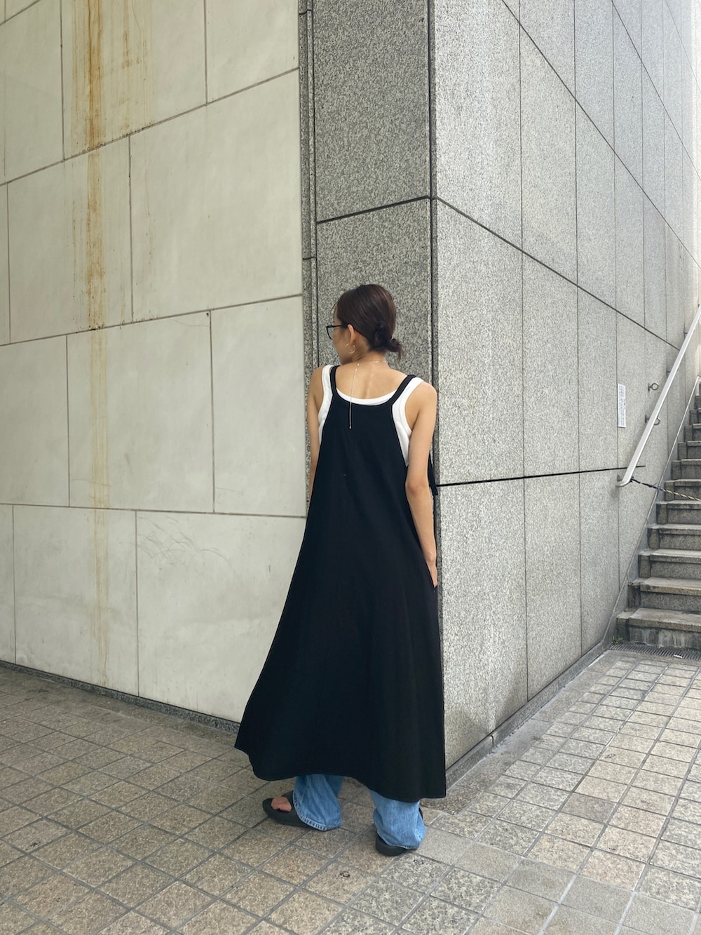 ブラック系のワンピース、ホワイト系のタンクトップ、ブルー系のデニムパンツを着用したレディースの夏コーディネートの3枚目の写真