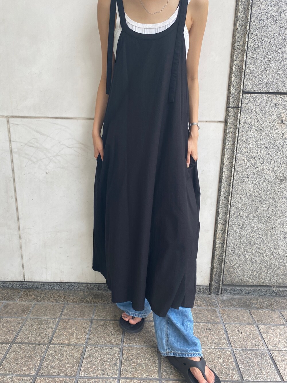 ブラック系のワンピース、ホワイト系のタンクトップ、ブルー系のデニムパンツを着用したレディースの夏コーディネートの5枚目の写真