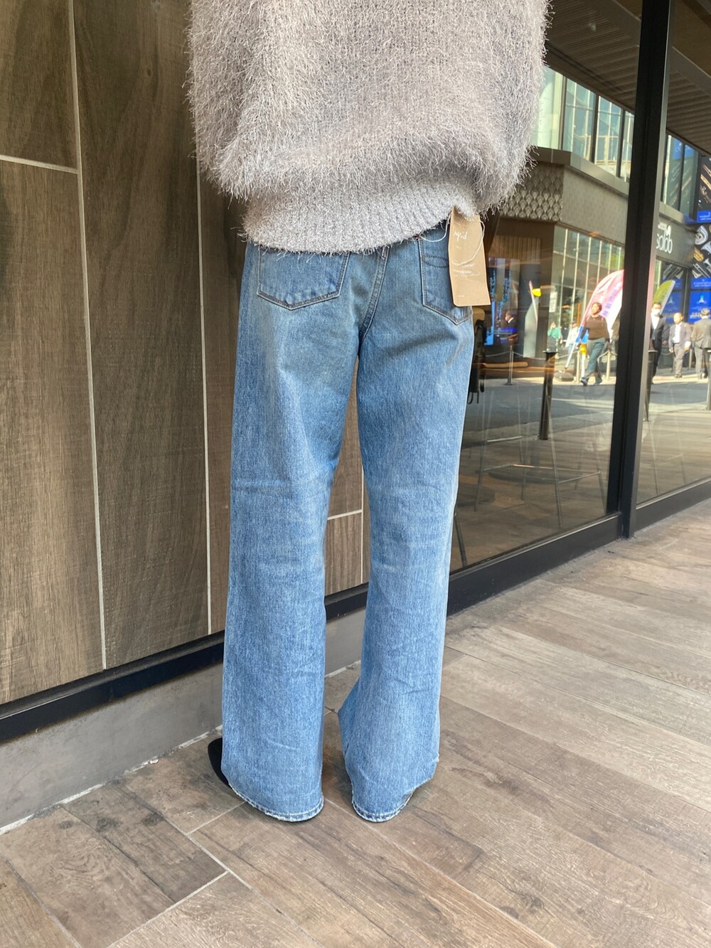 シルバー系のニット/セーター、ブルー系のデニムパンツを着用したレディースの秋コーディネートの5枚目の写真