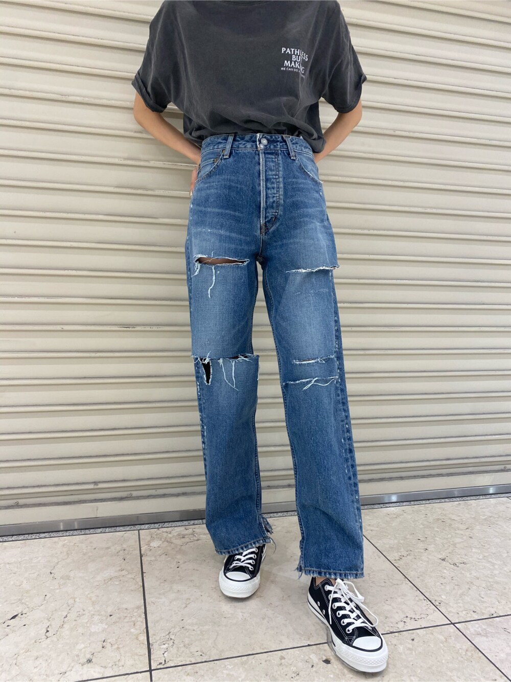 ブルー系のデニムパンツ、ゴールド系のブレスレット、ブラウン系のメガネを着用したレディースの春コーディネートの3枚目の写真