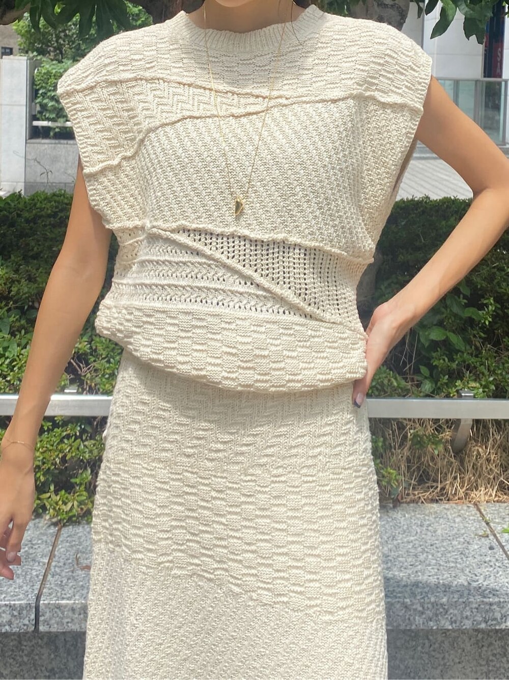 ホワイト系のスカート、ホワイト系のニット/セーター、ゴールド系のネックレスを着用したレディースの夏コーディネートの4枚目の写真