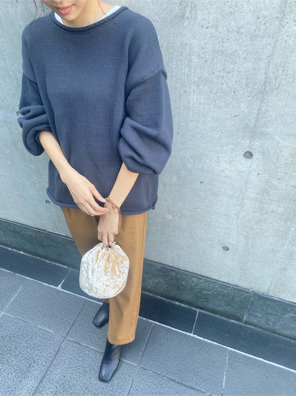 ブラウン系のその他パンツ、ブラック系のブーツ、ホワイト系のハンドバッグを着用したレディースの秋コーディネートの7枚目の写真