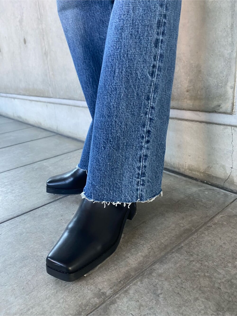 ブラック系のブルゾン、ブルー系のデニムパンツ、グレー系のニット/セーターを着用したレディースの秋コーディネートの7枚目の写真