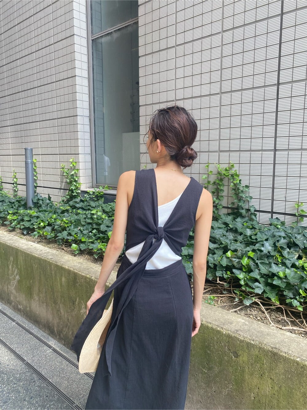 ブラック系のワンピース、ブラック系のサンダル、ホワイト系のタンクトップを着用したレディースの夏コーディネートの4枚目の写真