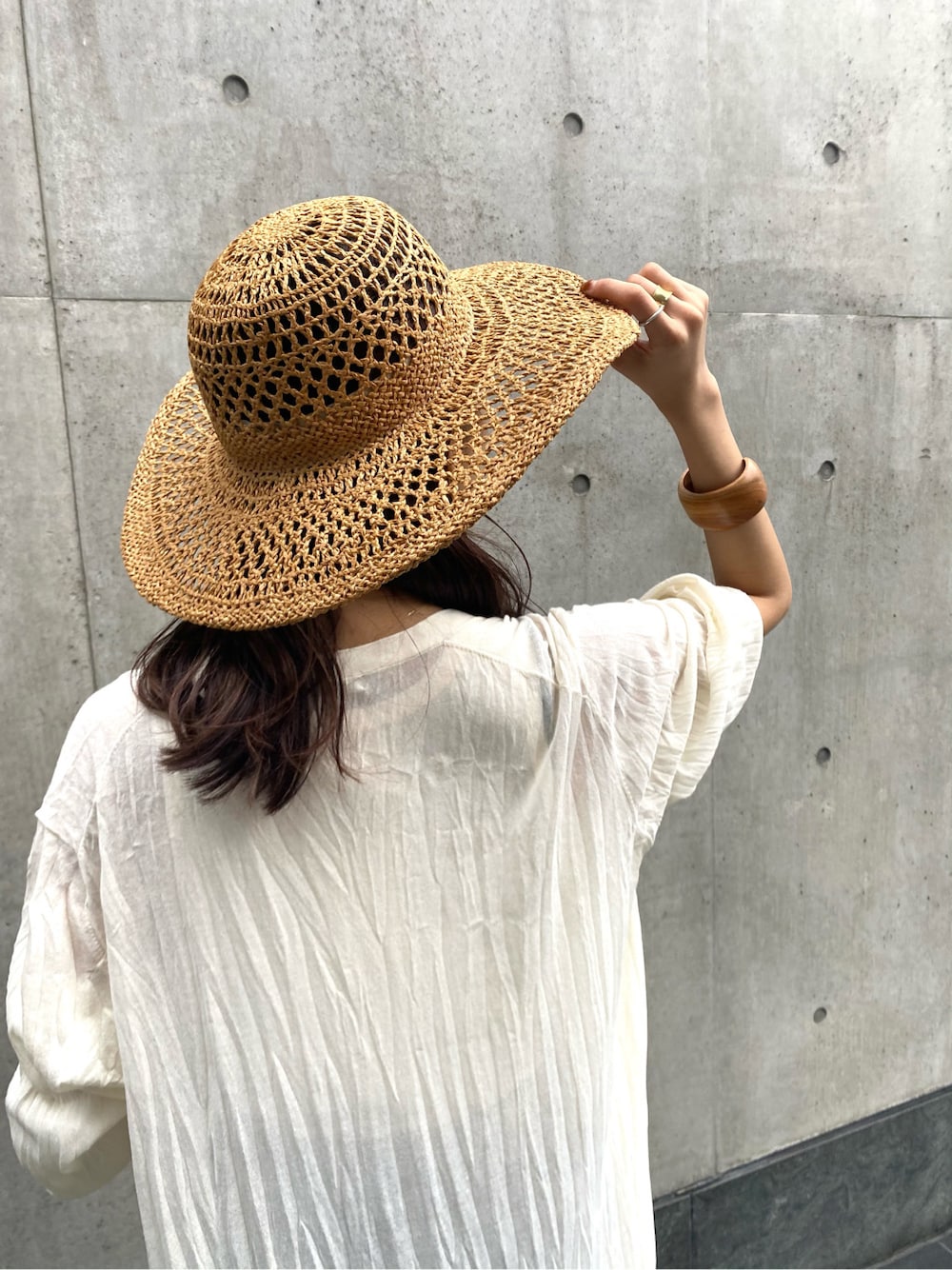 ホワイト系のタンクトップ、ブルー系のデニムパンツ、ホワイト系のカーディガン/ボレロを着用したレディースの春コーディネートの6枚目の写真