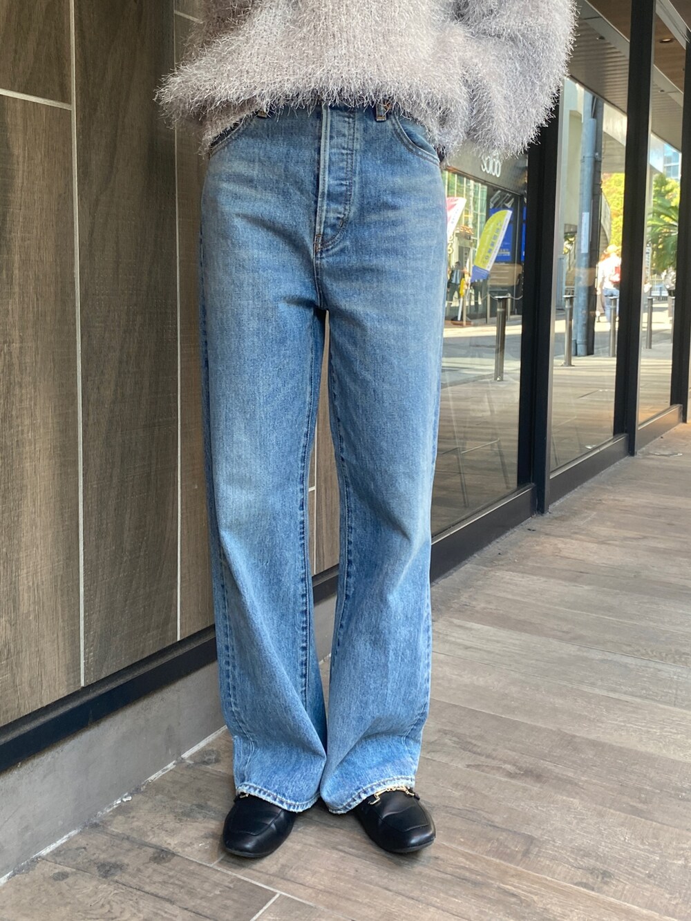 シルバー系のニット/セーター、ブルー系のデニムパンツを着用したレディースの秋コーディネートの4枚目の写真