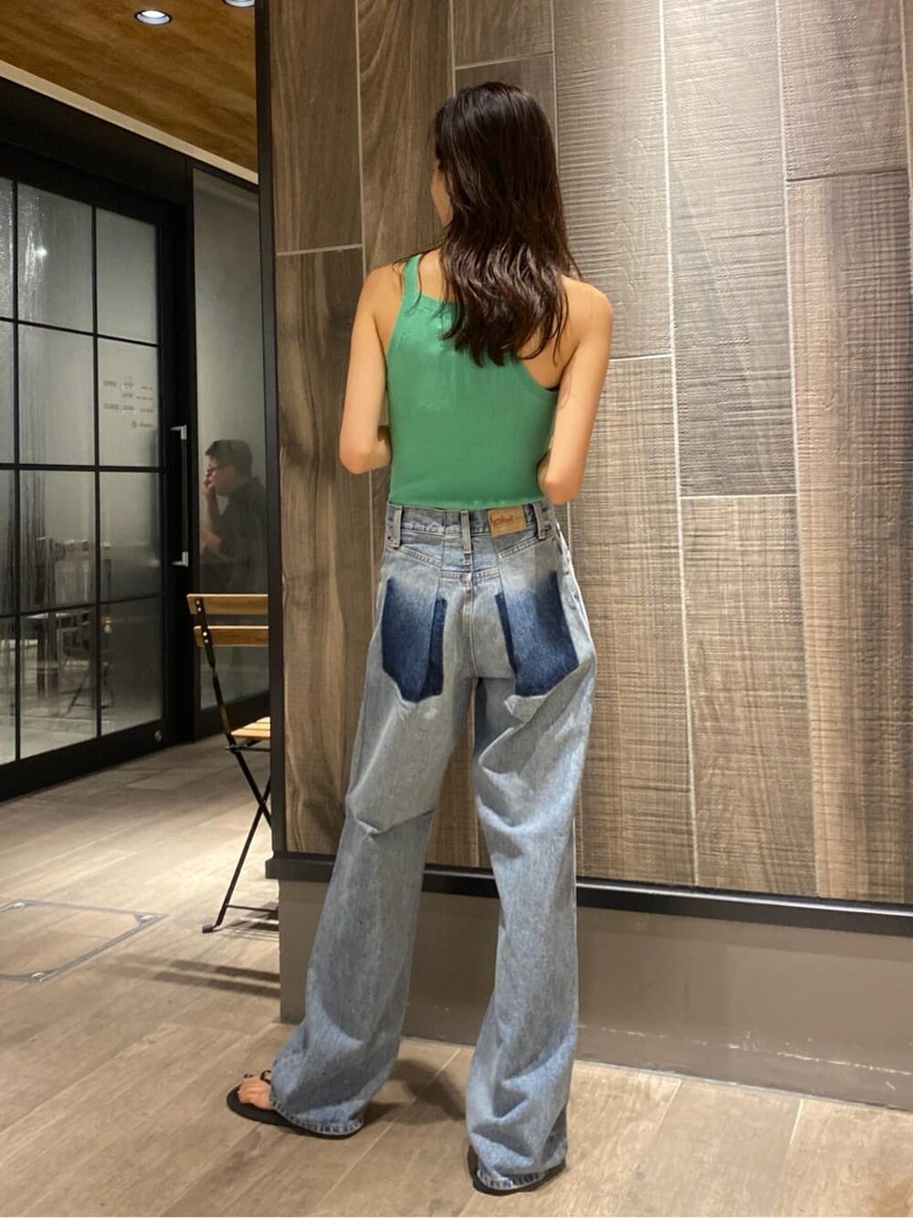 グリーン系のタンクトップ、ブルー系のデニムパンツを着用したレディースの夏コーディネートの2枚目の写真