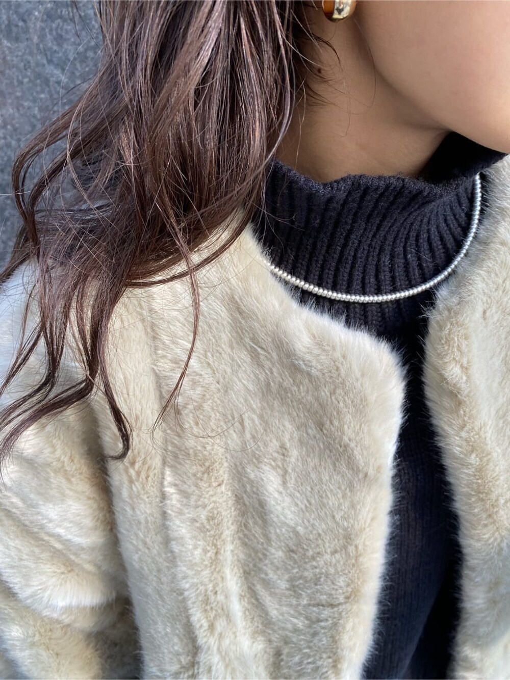 グレー系のその他アウター、ブルー系のデニムパンツ、ブラック系のニット/セーターを着用したレディースの冬コーディネートの5枚目の写真