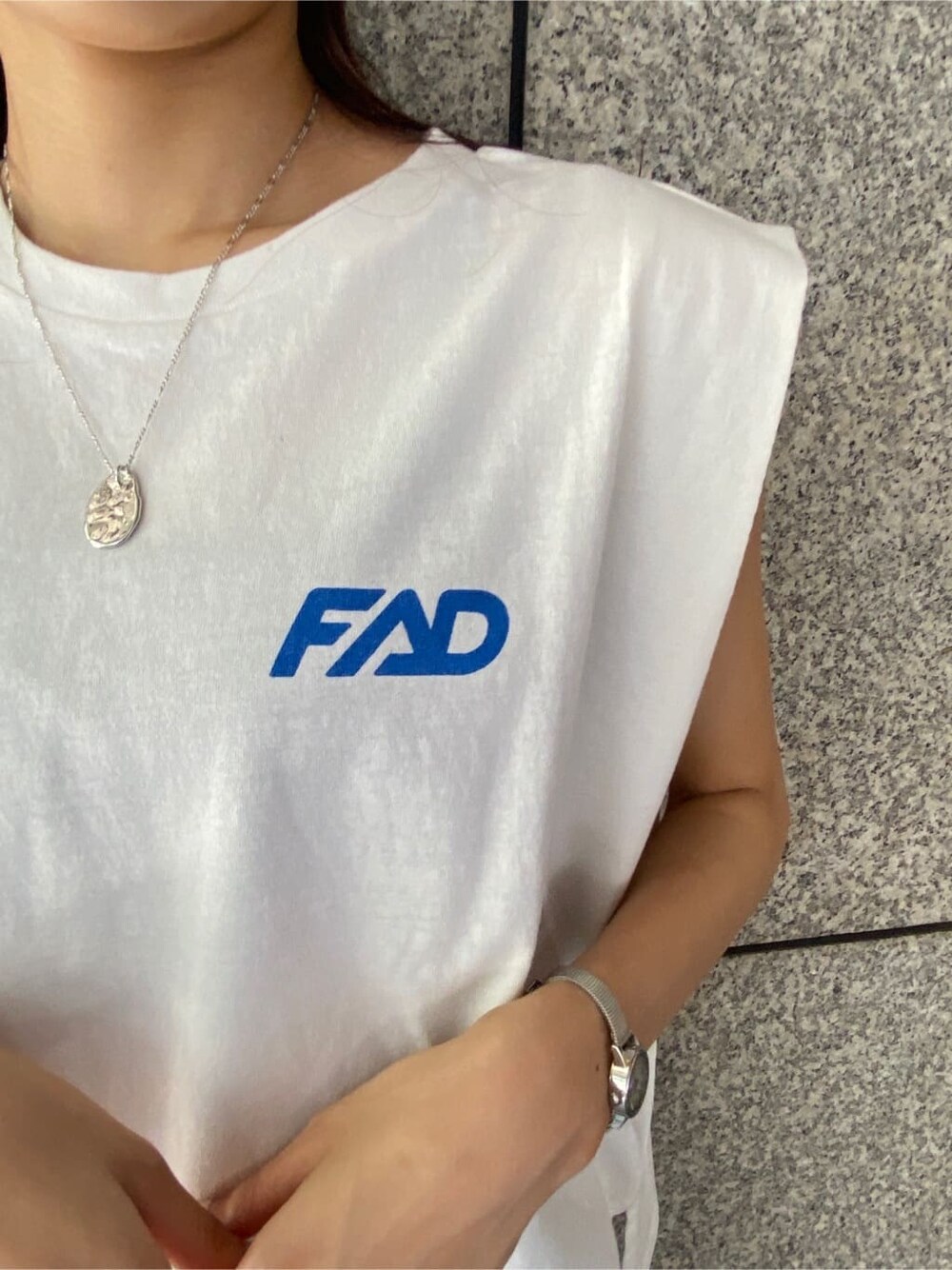 グレー系のスカート、ホワイト系のタンクトップ、シルバー系のネックレスを着用したレディースの春コーディネートの5枚目の写真