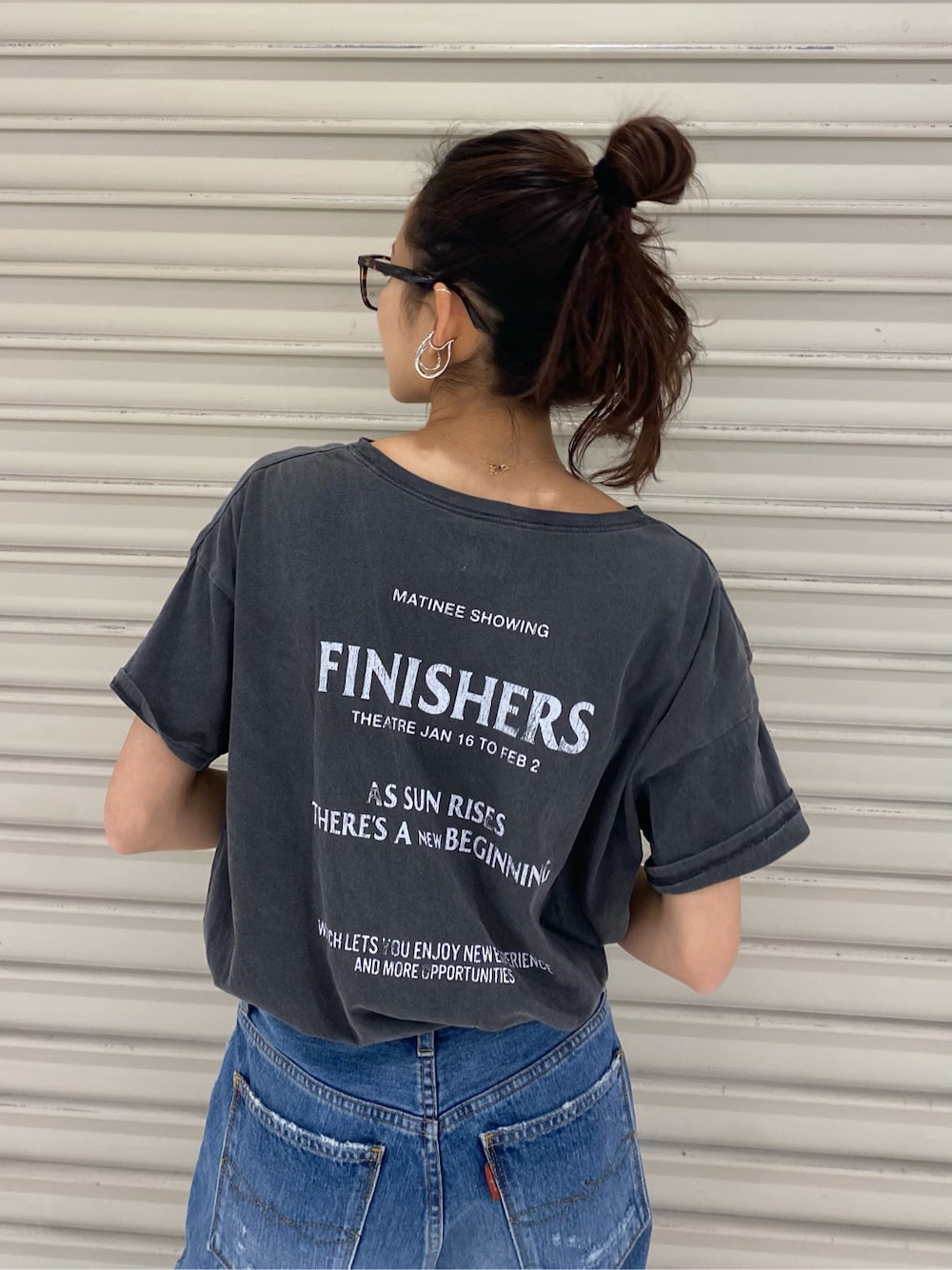 ブルー系のデニムパンツ、ゴールド系のブレスレット、ブラウン系のメガネを着用したレディースの春コーディネートの2枚目の写真