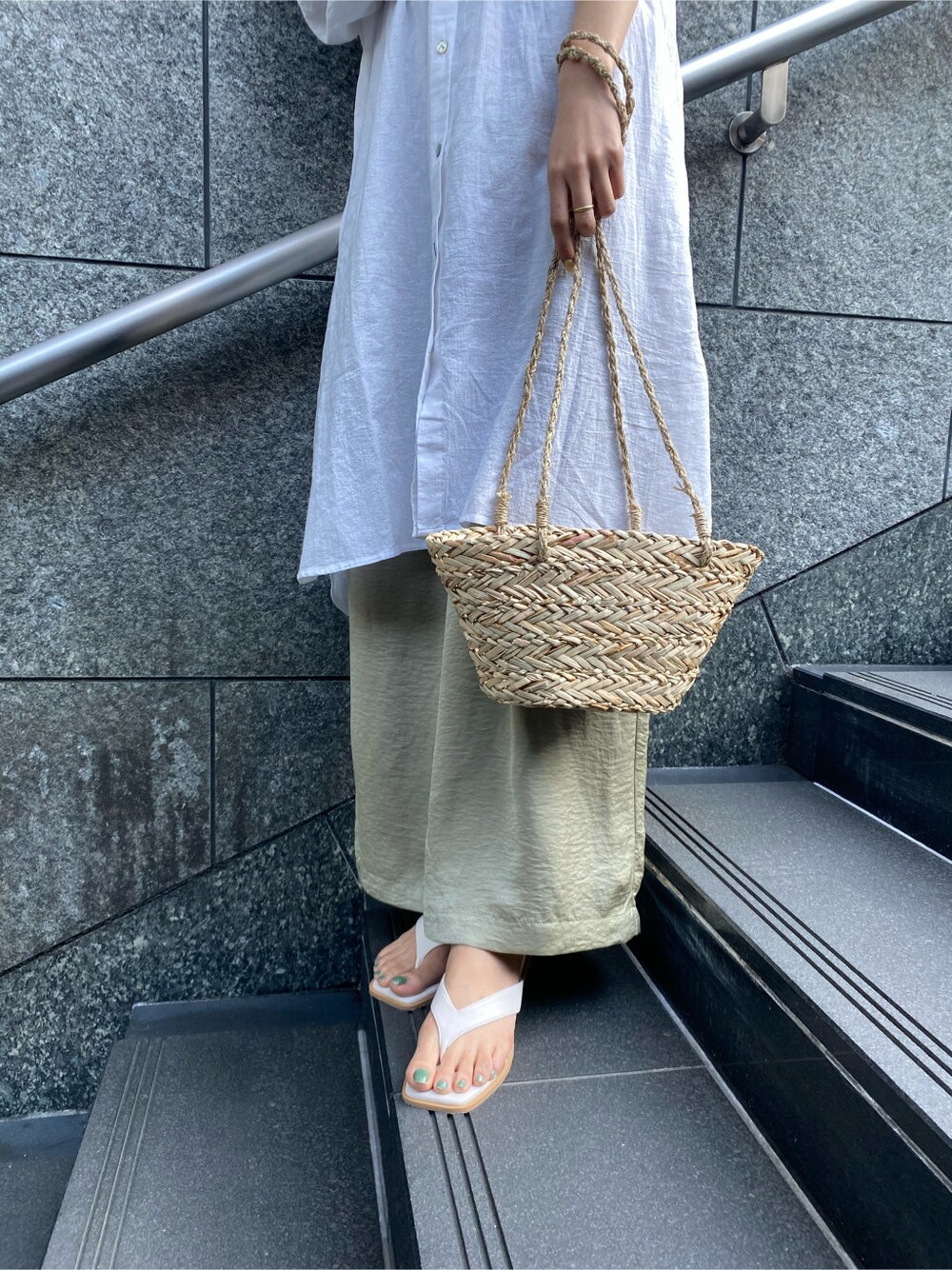 ホワイト系のサンダル、ベージュ系のかごバッグ、ホワイト系のワンピースを着用したレディースの春コーディネートの4枚目の写真