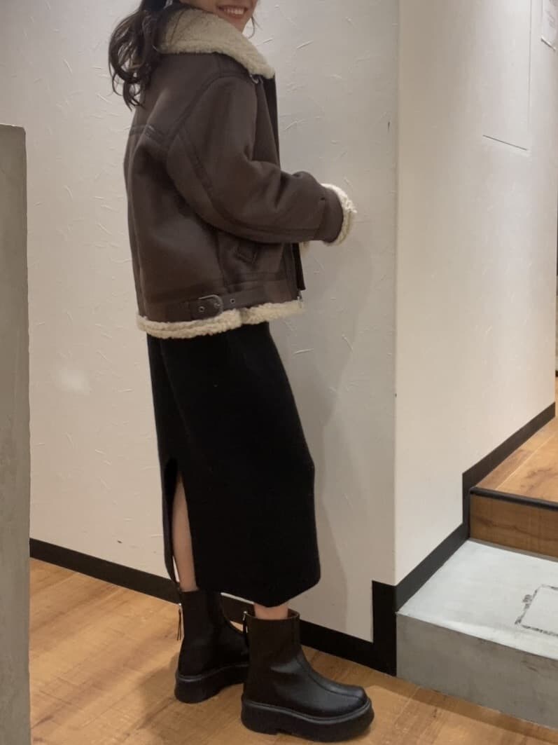 ブラック系のワンピース、ブラウン系のムートンコート、ホワイト系のTシャツ/カットソーを着用したレディースの秋コーディネートの2枚目の写真
