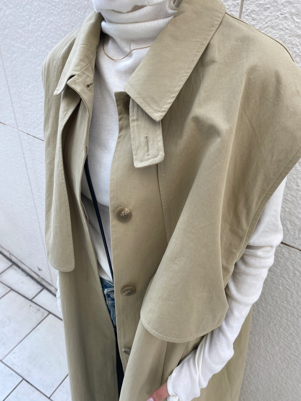ベージュ系のその他アウター、ホワイト系のTシャツ/カットソー、ブルー系のデニムパンツを着用したレディースの冬コーディネートの4枚目の写真