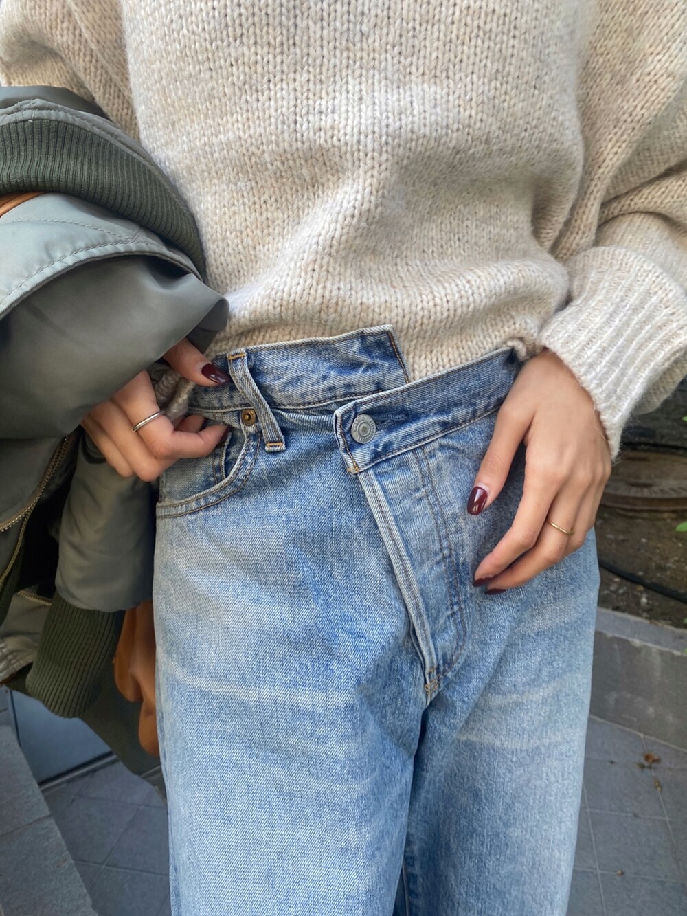 ホワイト系のニット/セーター、ブルー系のデニムパンツ、ブラック系のブーツを着用したレディースの秋コーディネートの8枚目の写真